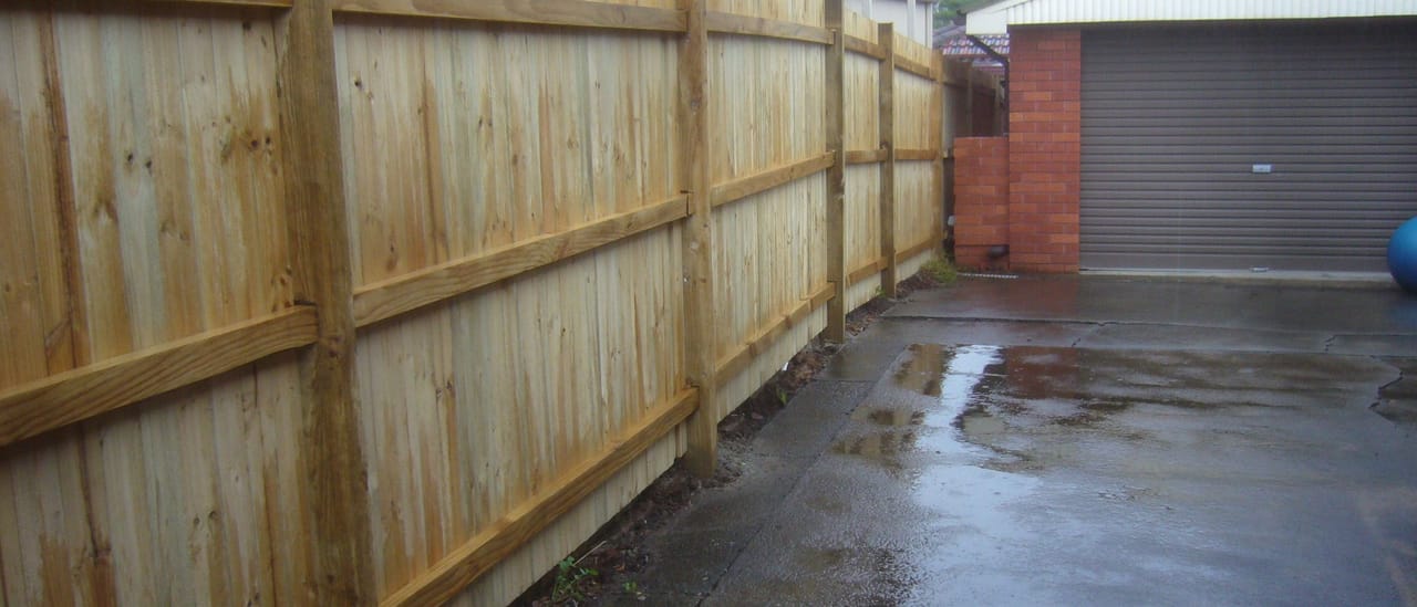 Long treated pine timber fence built along a driveway and carport boundary at a Sydney property