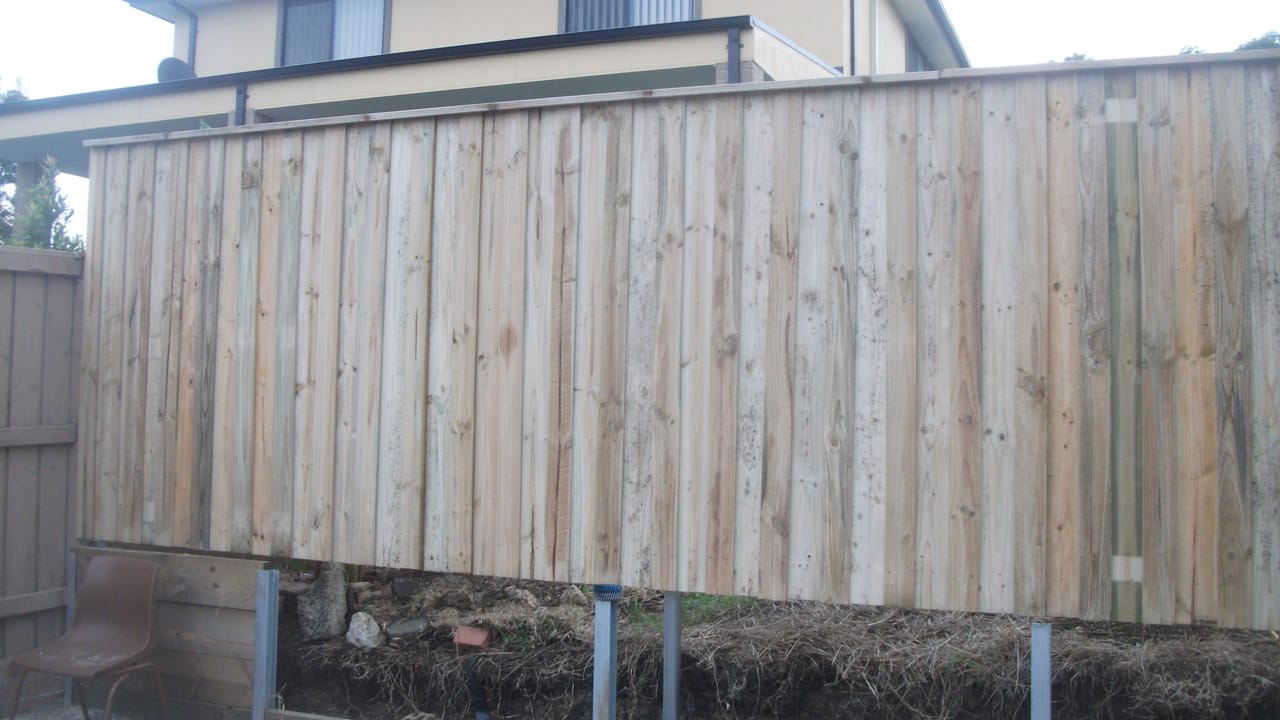 Newly installed treated pine timber paling fence running along a residential boundary beside a two-storey home in Northmead, Sydney